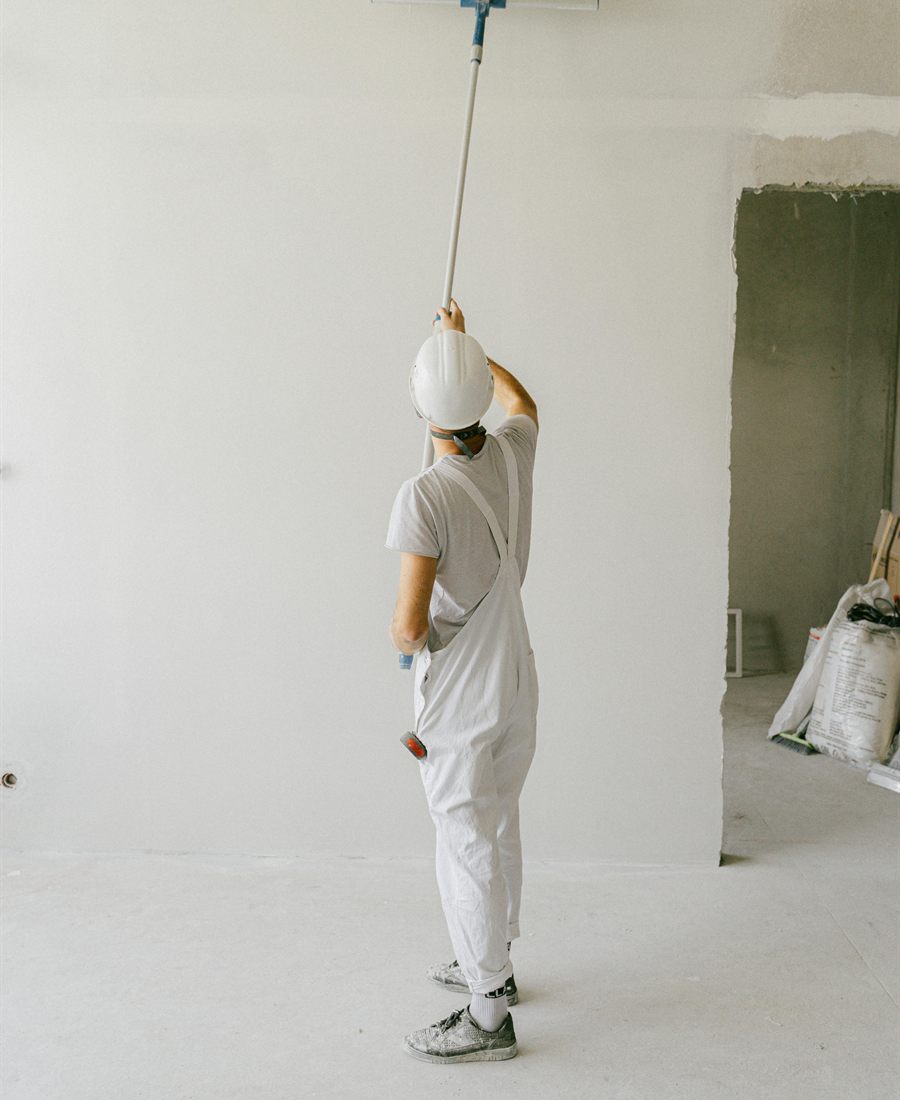 Interior wall being painted with a roller after room preparation